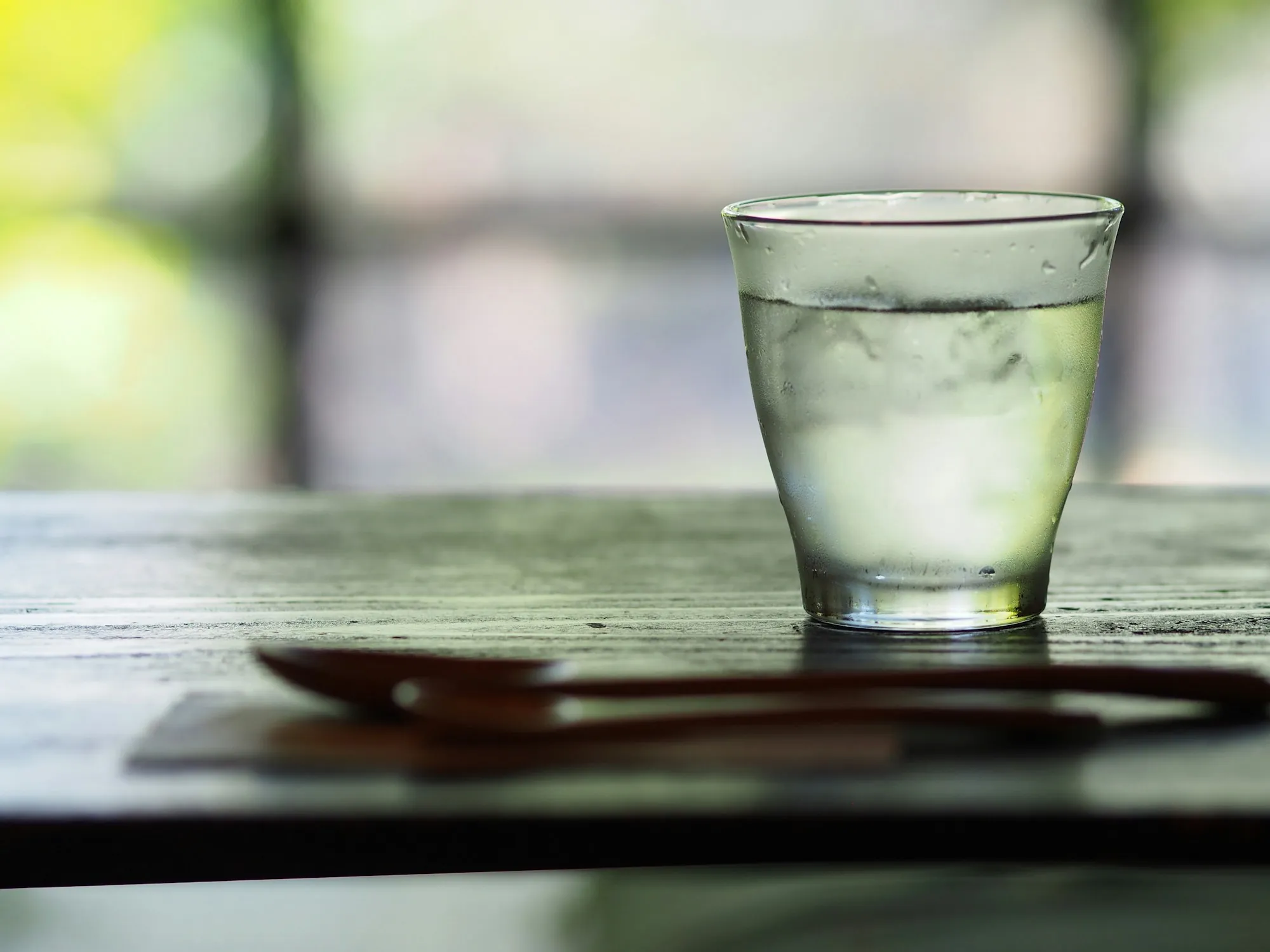 Water Filtration Tips & Resources for Aliso Viejo Homeowners Glass of water on a wooden table outdoors