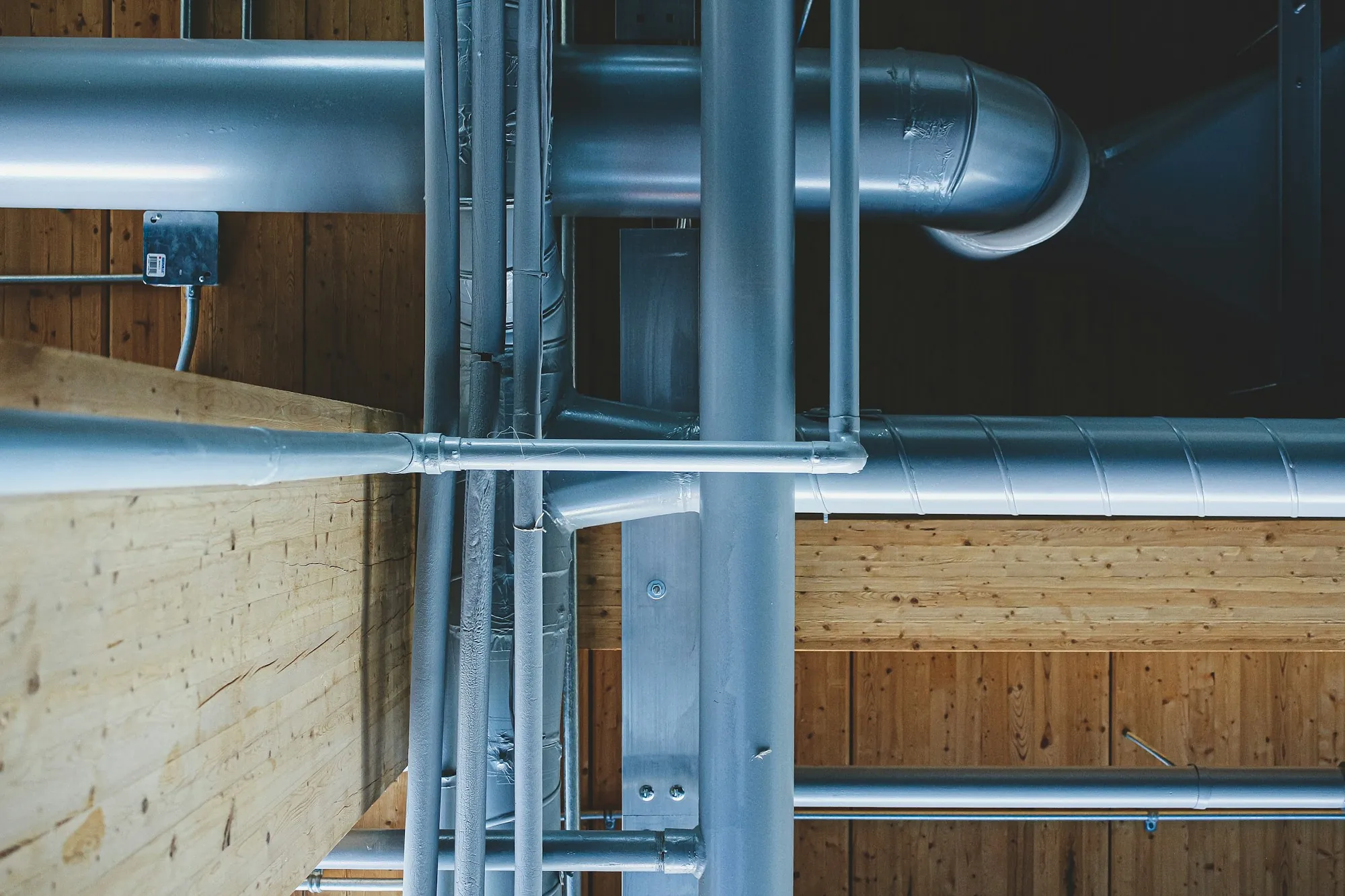 Whole-House Water Filtration in Aliso Viejo, CA Metal water pipes running along a wooden wall