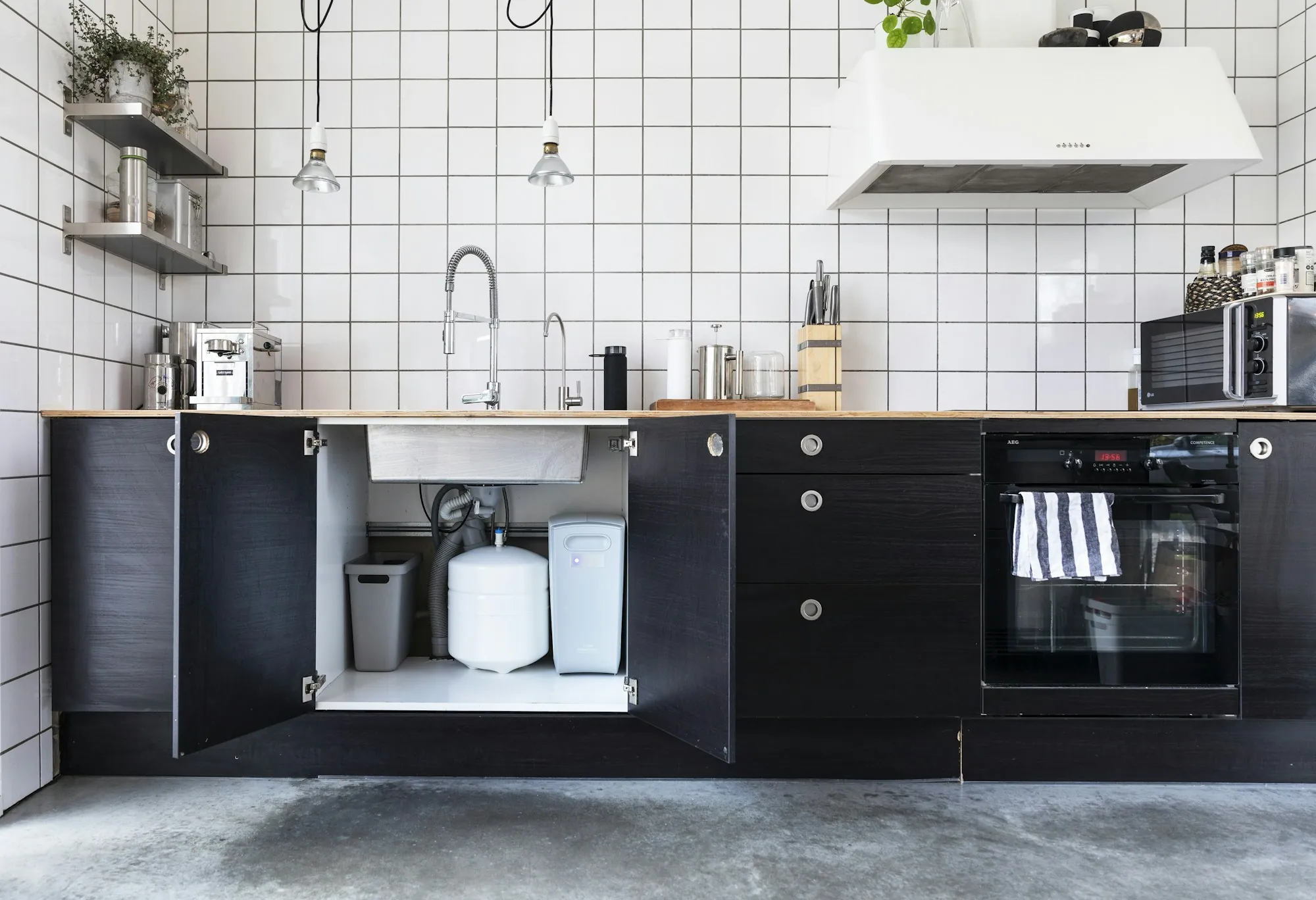 Under-Sink Drinking Water Filters in Aliso Viejo, CA Kitchen with an open sink cabinet and a water filter unit inside