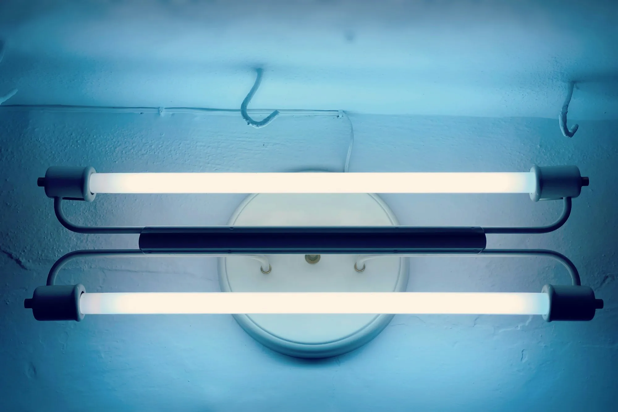 UV Water Purification in Aliso Viejo, CA Two glowing lamp tubes in a light blue fixture